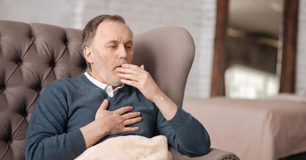 Man coughing and holding chest